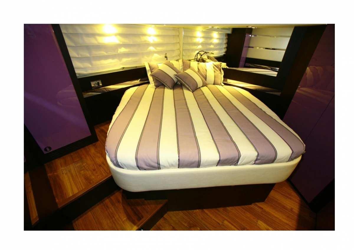 a bed with a white comforter aboard DADDA Yacht for Charter
