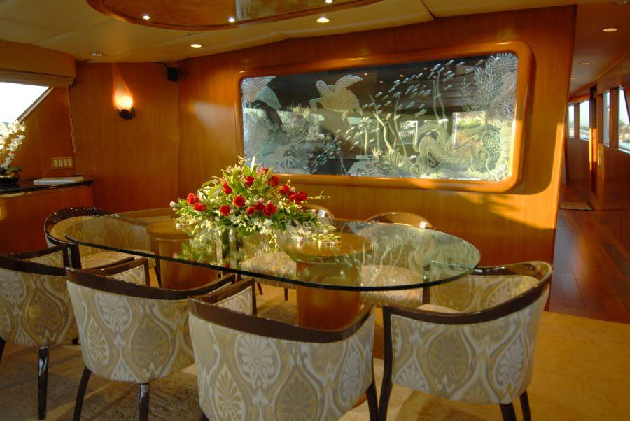 a table with chairs and a painting aboard KALEEN Yacht for Charter