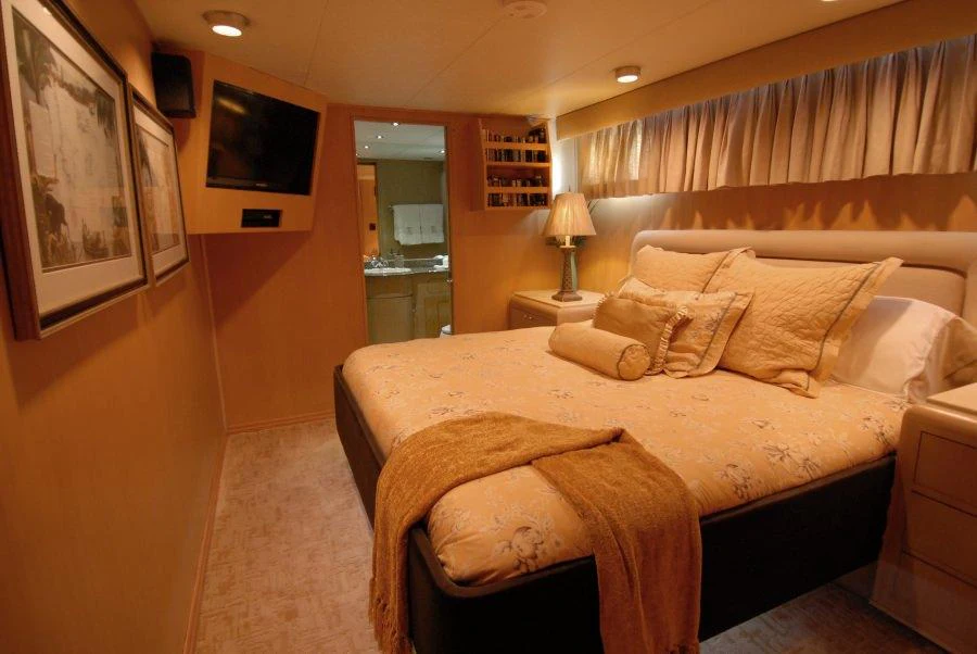 a bedroom with a bed and a television aboard KALEEN Yacht for Charter