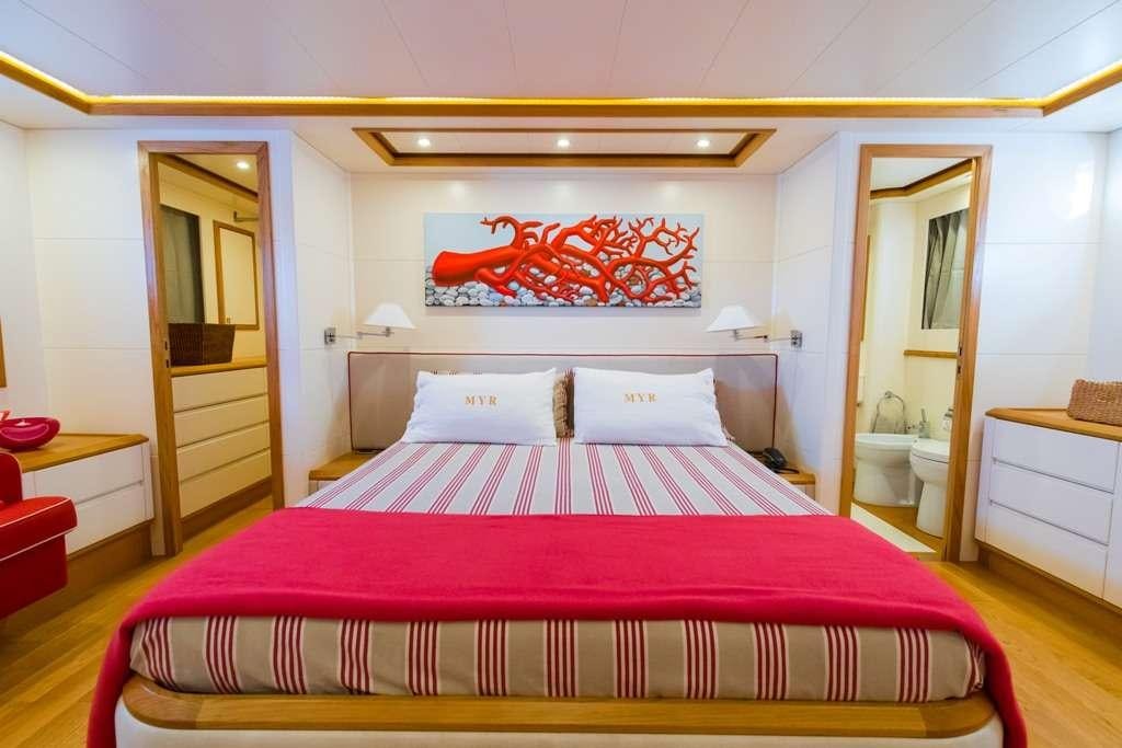a bed with pink sheets aboard RIVIERA Yacht for Charter