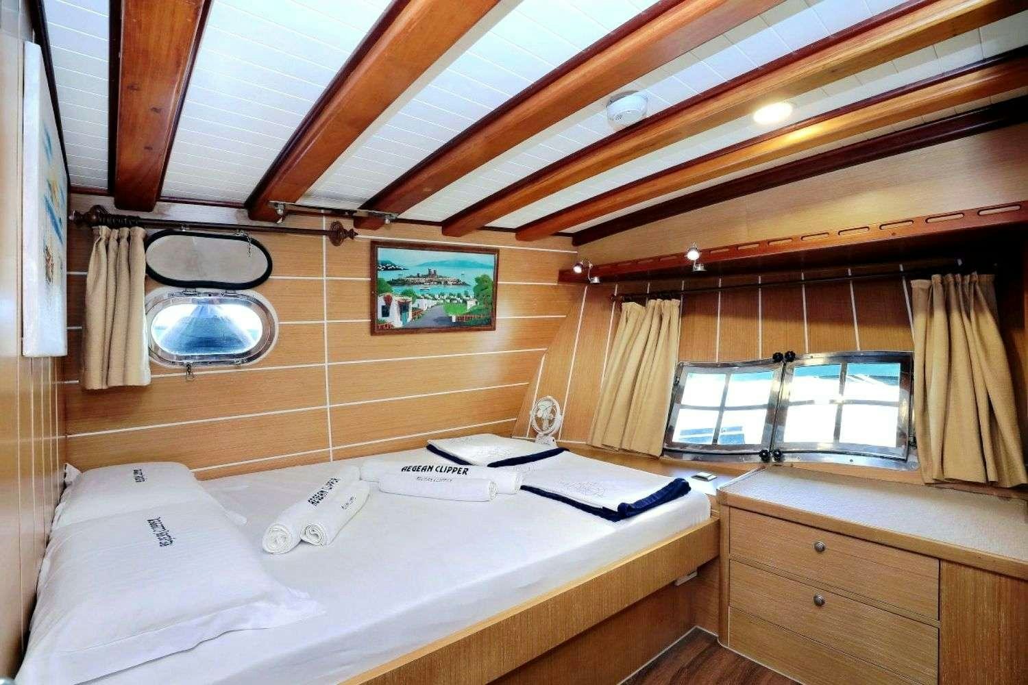 a room with a bed and a window aboard AEGEAN CLIPPER Yacht for Charter