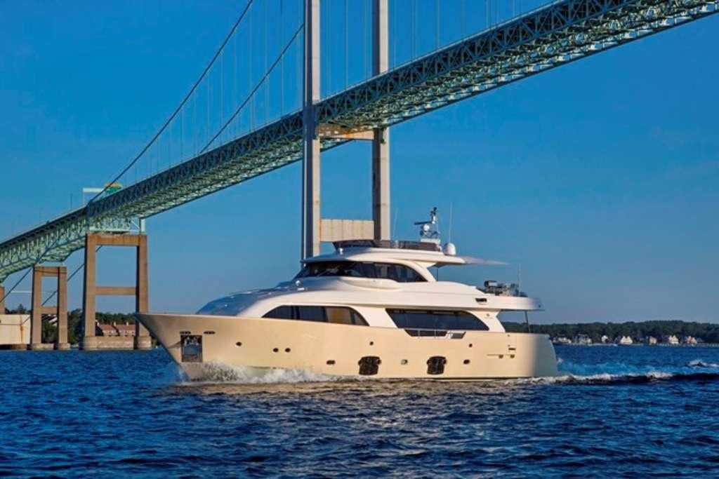 a white yacht under a bridge aboard SLAINTE III Yacht for Charter