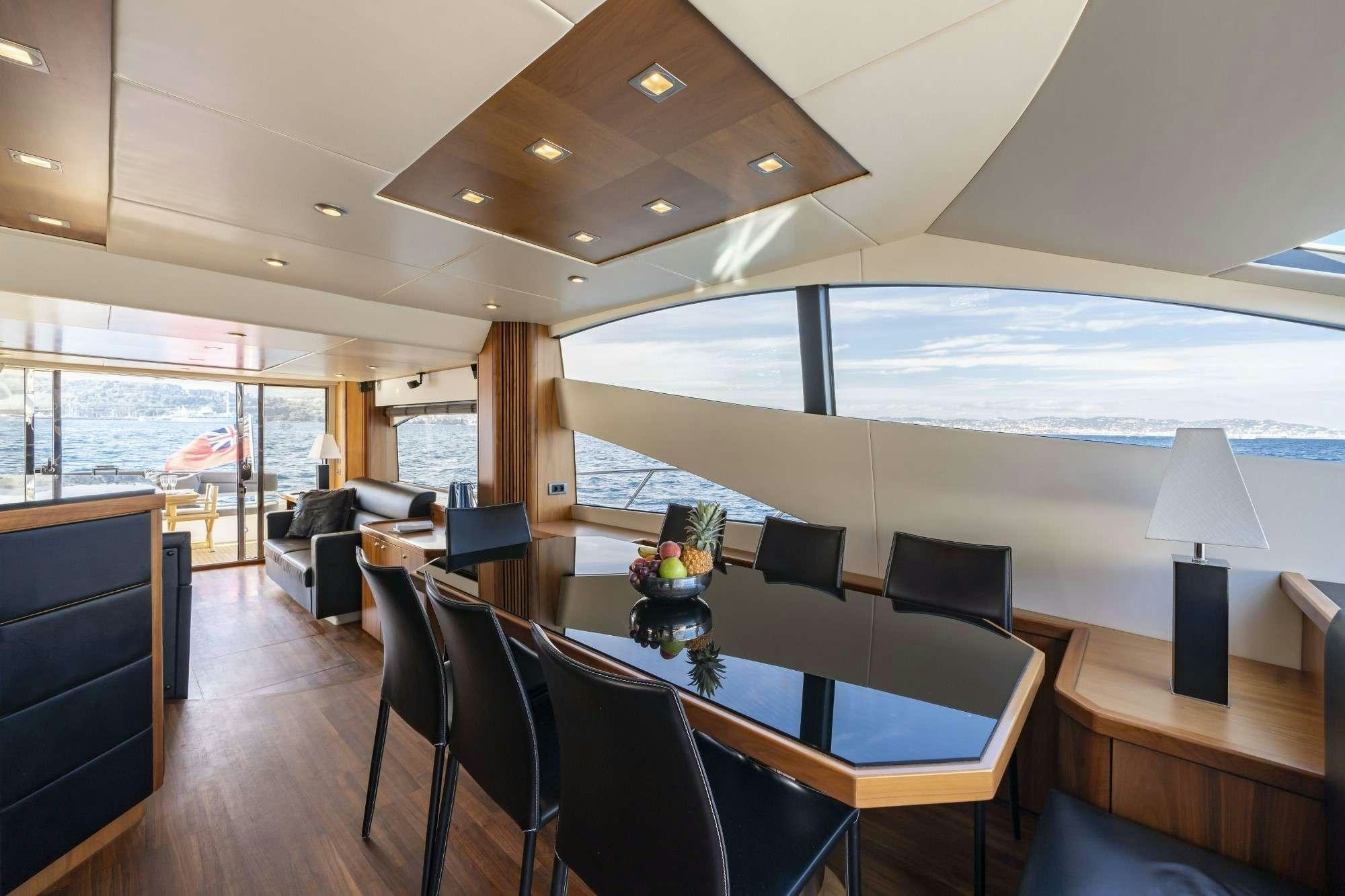 a large room with a table and chairs and a large window aboard LAZY P Yacht for Charter
