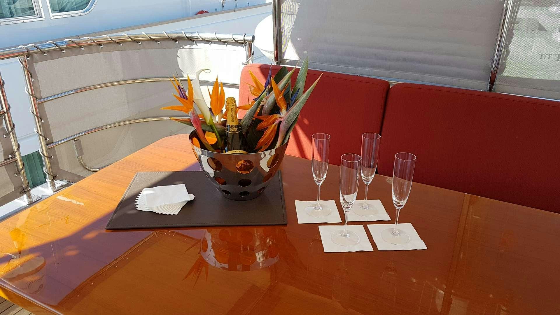 a table with wine glasses and a potted plant on it aboard TEMPEST WS Yacht for Charter