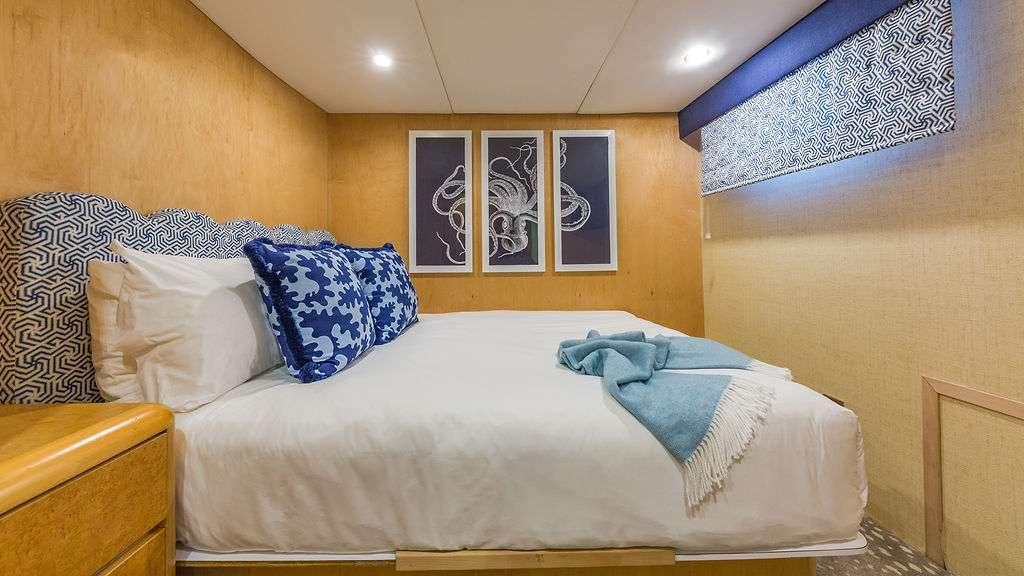 a bed with blue and white pillows aboard ALEXANDRA JANE Yacht for Charter