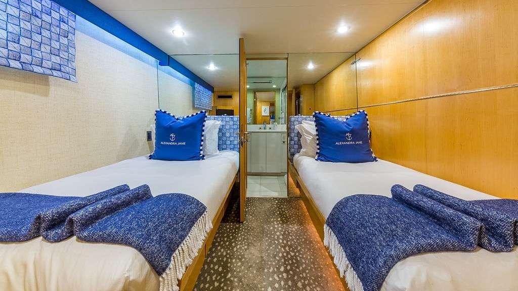 a room with a couple beds aboard ALEXANDRA JANE Yacht for Charter