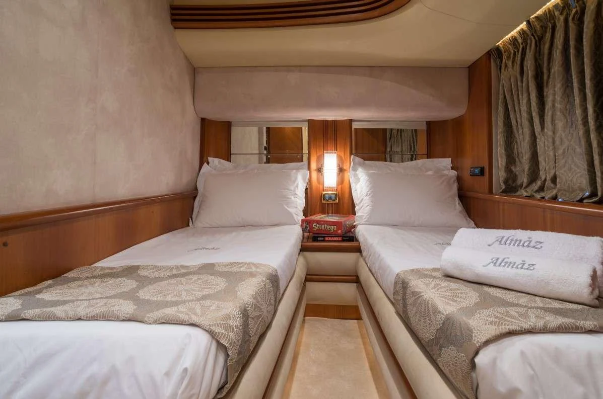 a room with beds and a lamp aboard ALMAZ Yacht for Charter