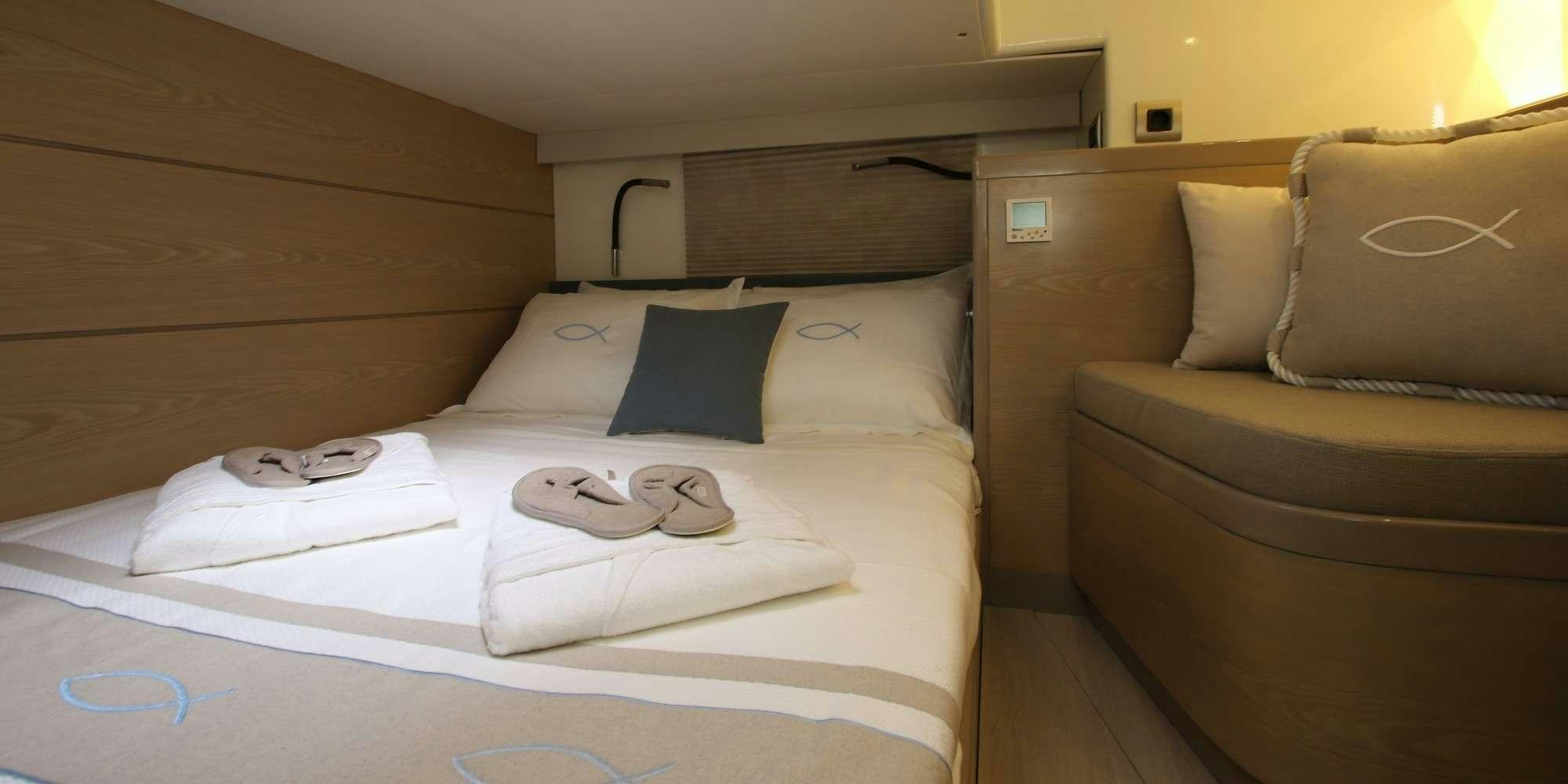 a bed with white sheets and pillows aboard ICHTUS Yacht for Charter