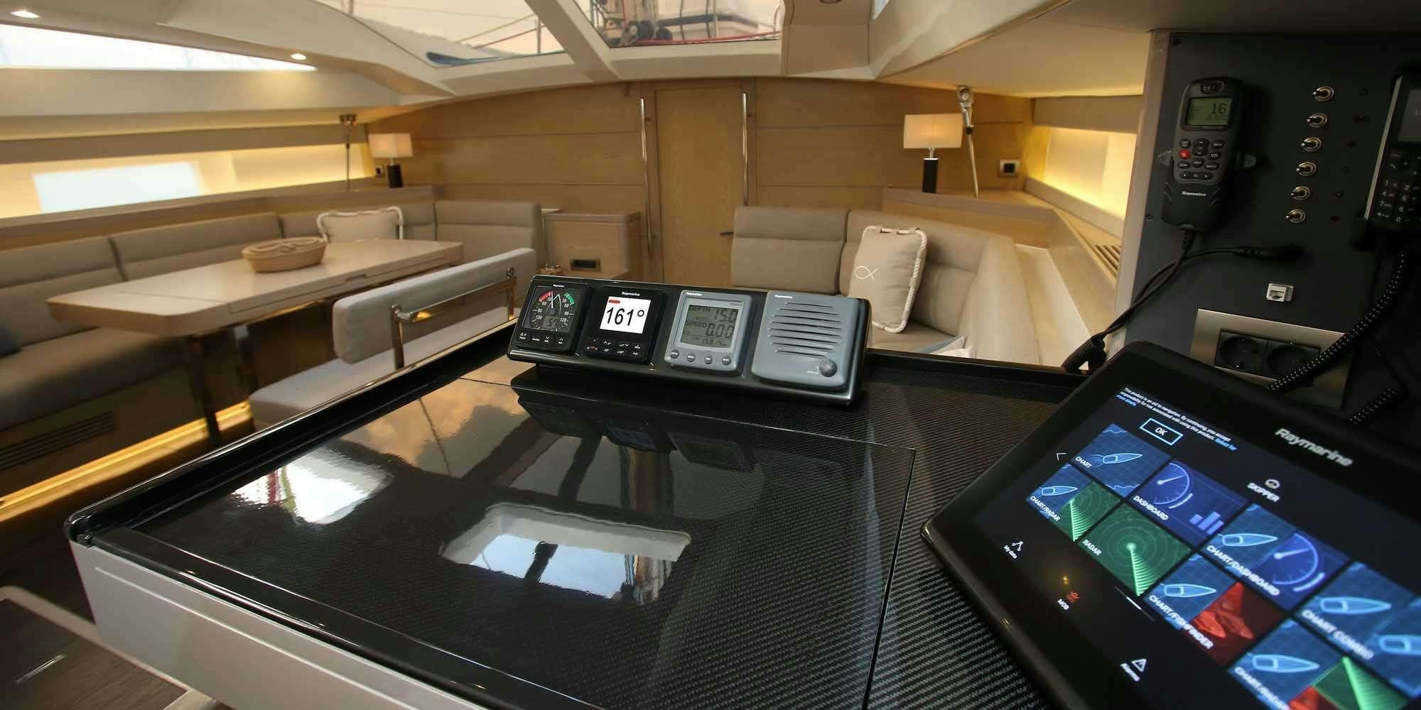 a desk with a phone and a computer on it aboard ICHTUS Yacht for Charter