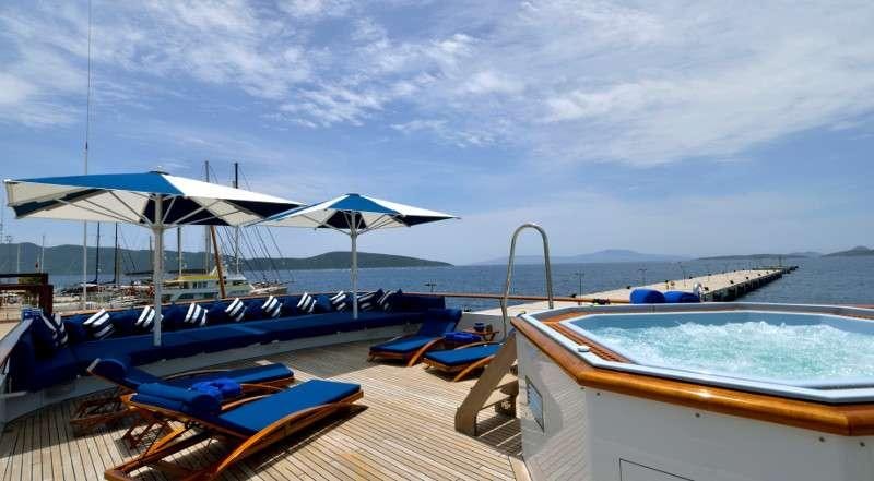 a deck with a pool and umbrellas on it aboard THE MERCY BOYS Yacht for Charter