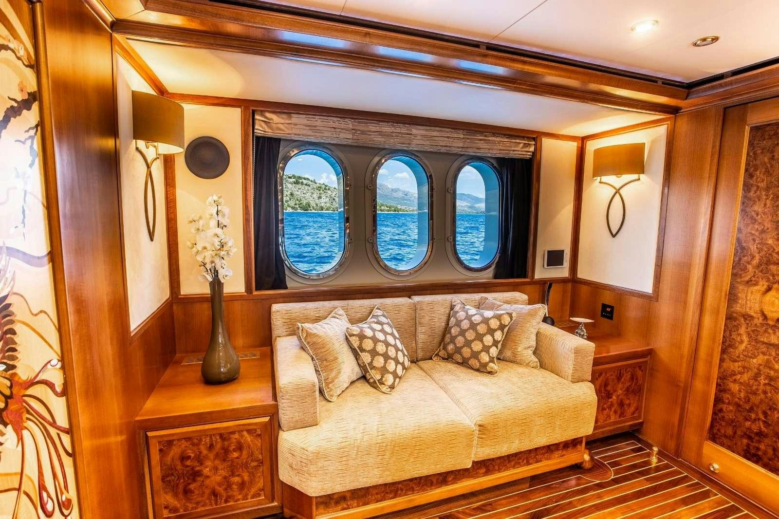 a living room with a couch and a window aboard MILAYA Yacht for Charter