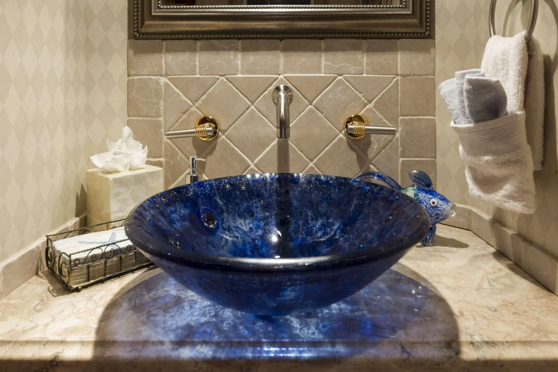 a blue round basin with a clear glass top and a marbled counter top with a marbled aboard IL CAPO Yacht for Charter