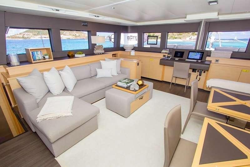 a room with a couch and a table with a tv on it aboard LE REVE L620 ESSENCE Yacht for Charter