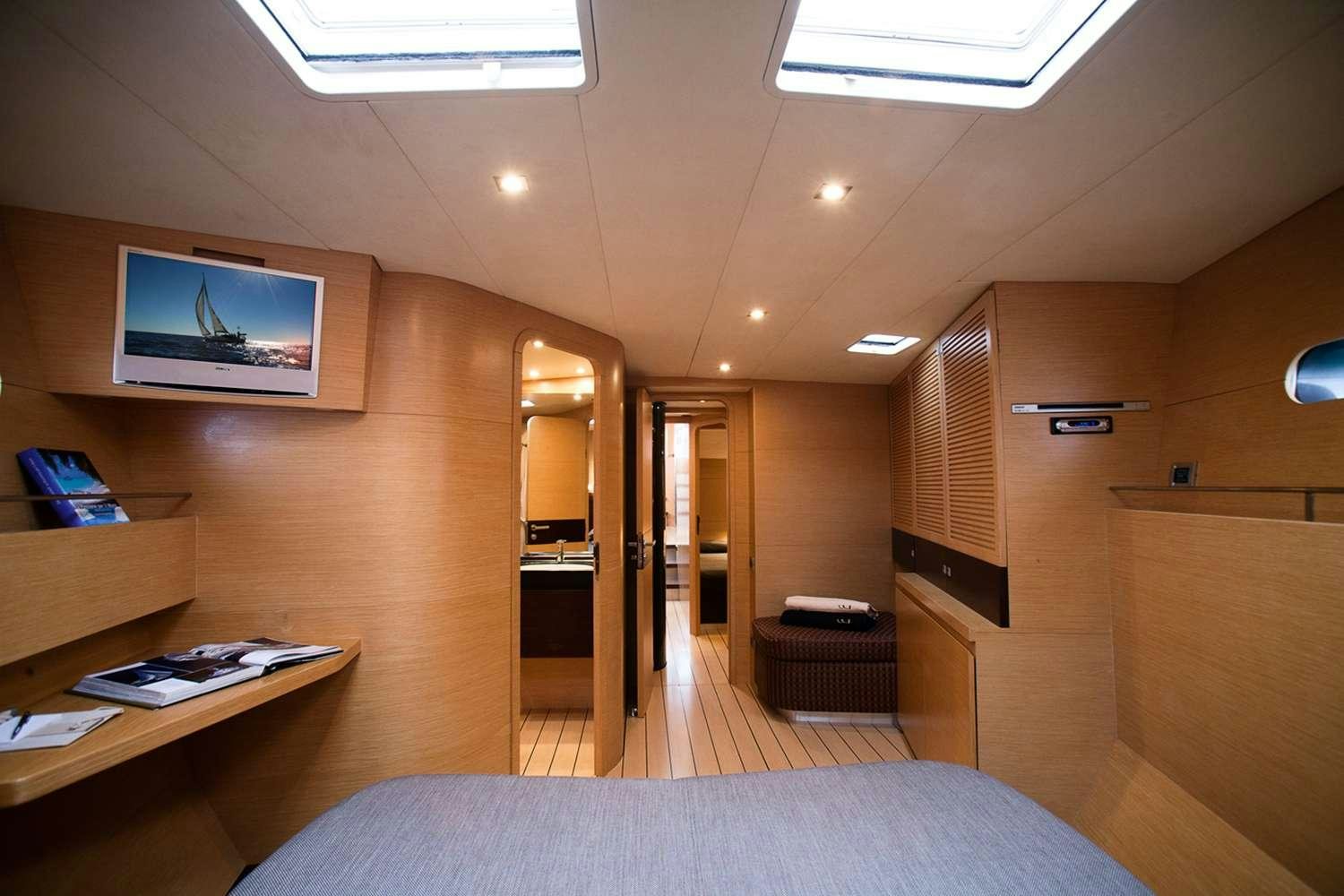 a room with a bed and a tv on the wall aboard WIZARD Yacht for Charter