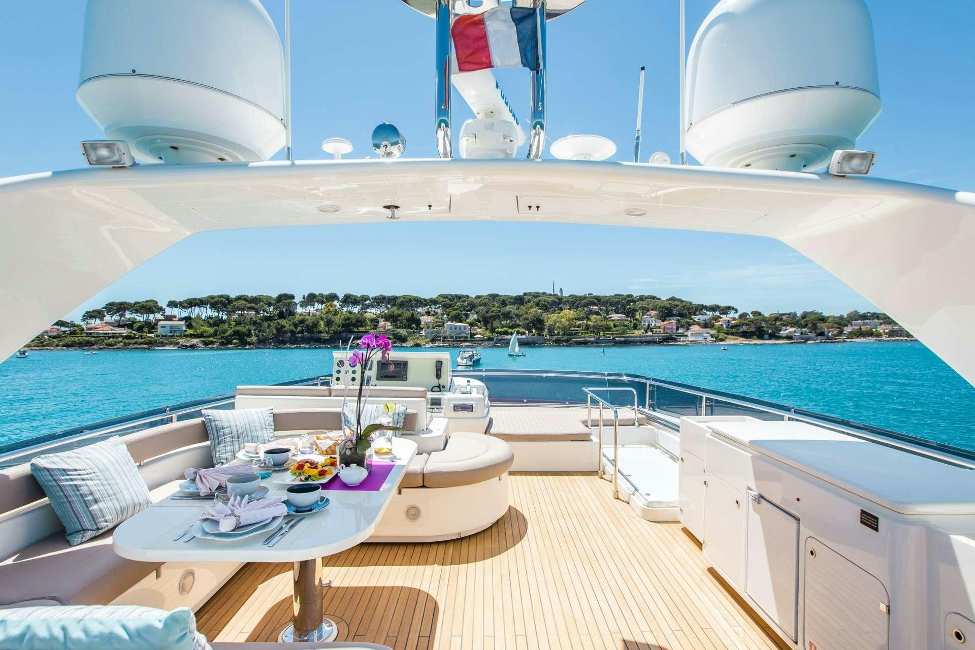 a room with a table and chairs and a view of a city aboard PIOLA Yacht for Charter