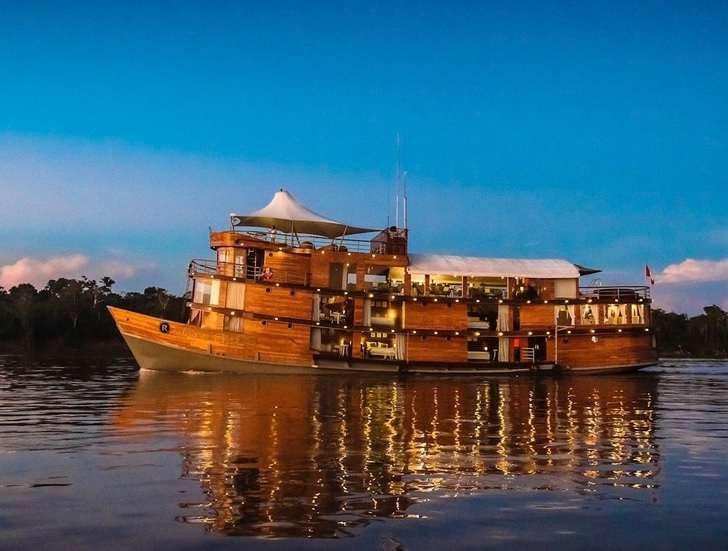 a building on a body of water aboard CRUCERO AMAZONAS Yacht for Charter