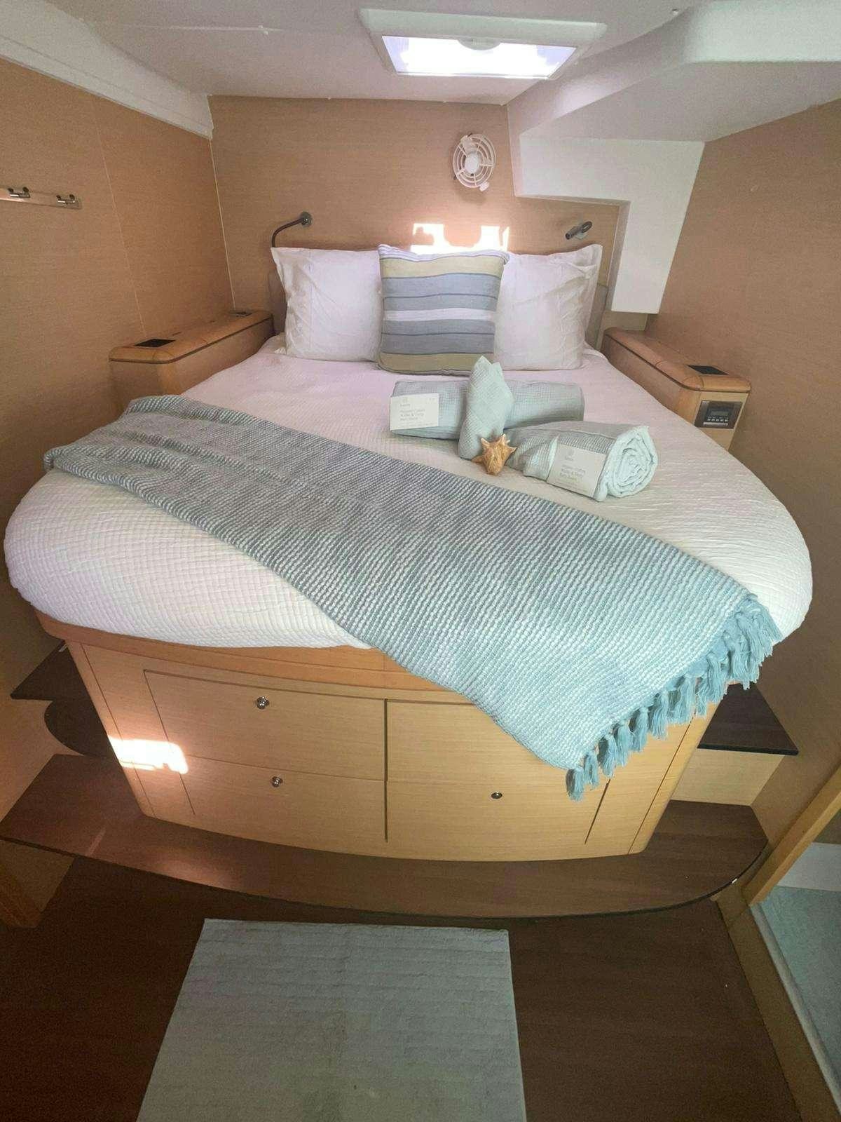a bed with a white comforter aboard CATATONIC 500 Yacht for Charter