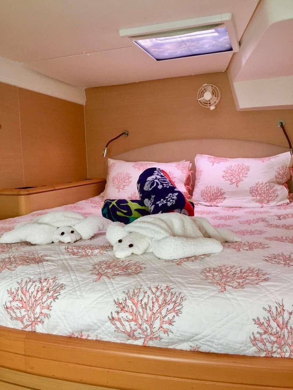 a bed with a stuffed animal on it aboard CATATONIC 500 Yacht for Charter