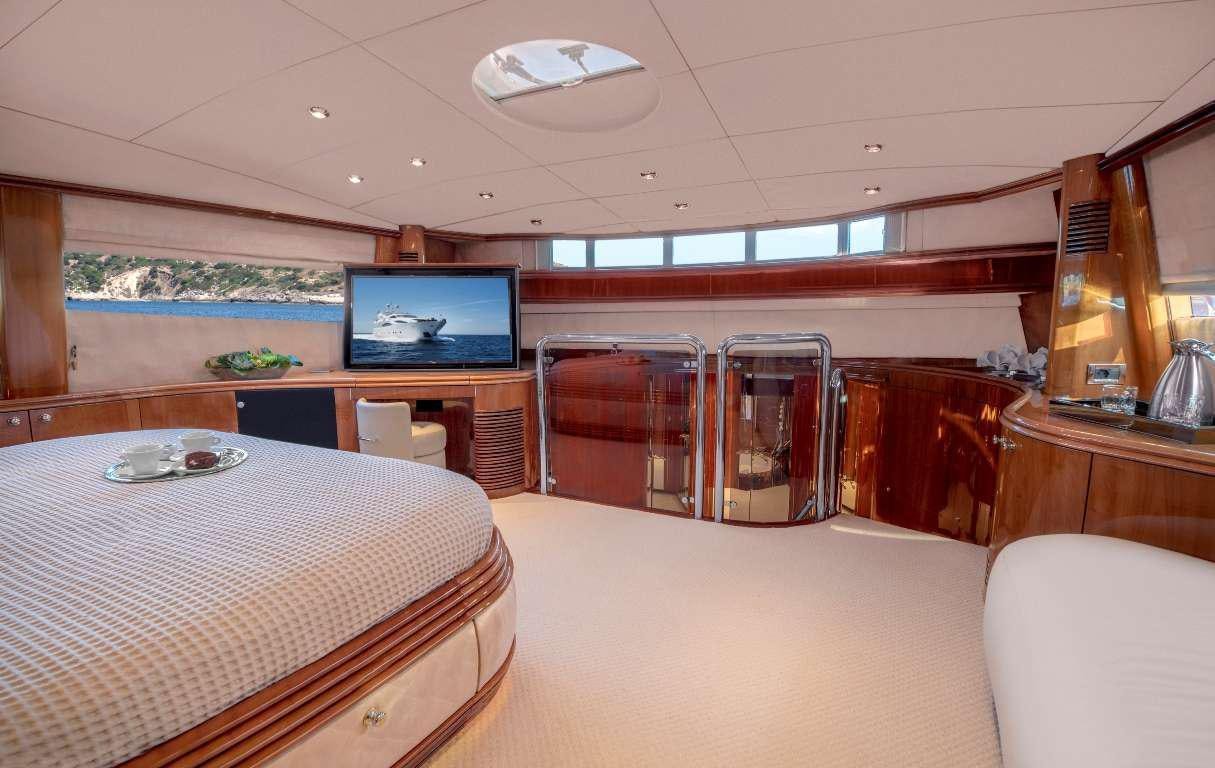 a room with a bed and a television aboard MI ALMA Yacht for Charter