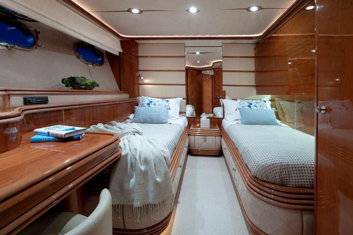 a room with beds and a desk aboard MI ALMA Yacht for Charter