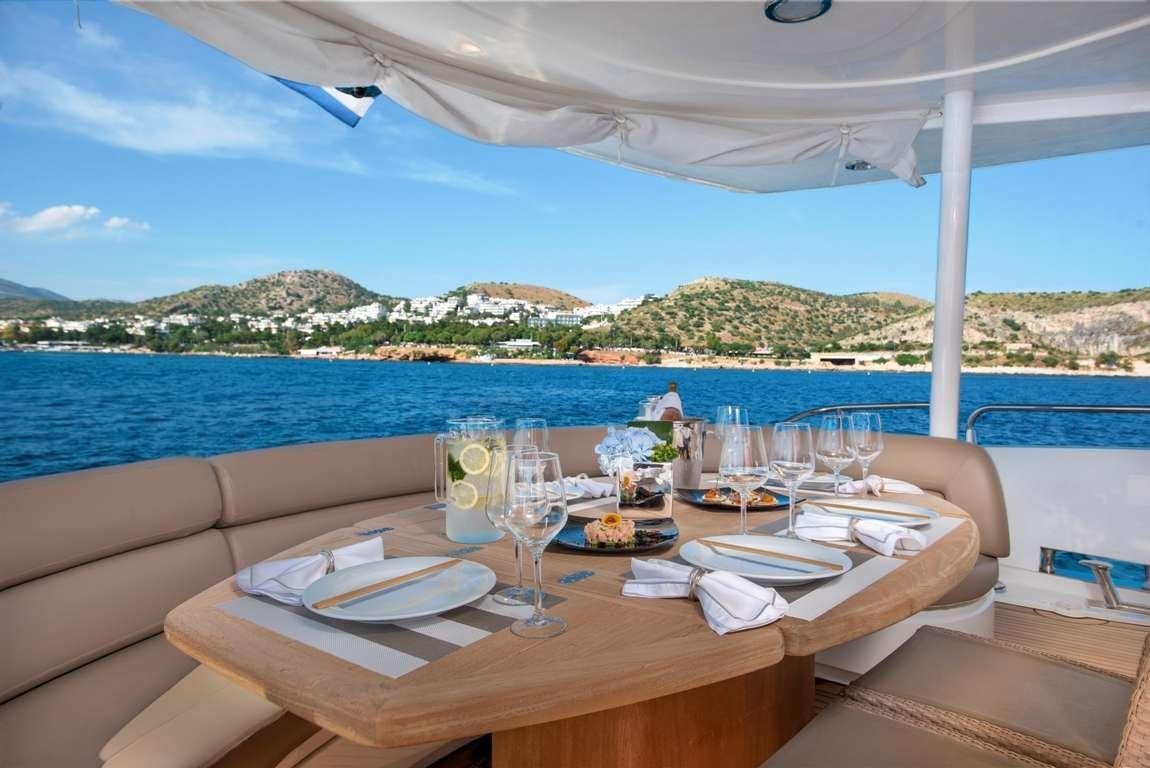 a table set for a meal on a beach aboard MI ALMA Yacht for Charter