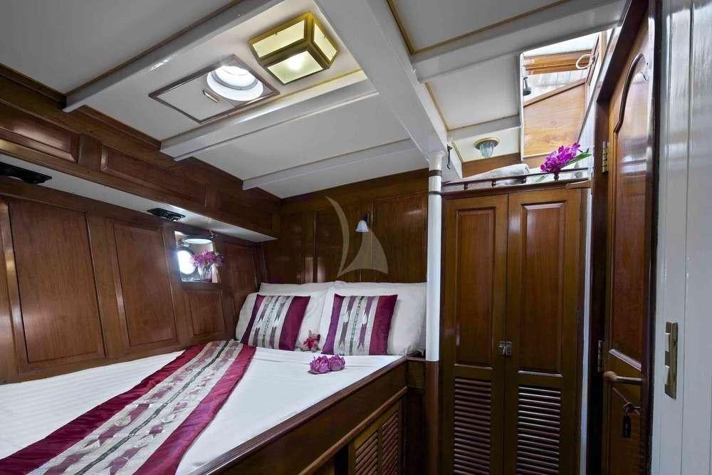 a room with a bed and a mirror aboard Sunshine Yacht for Charter