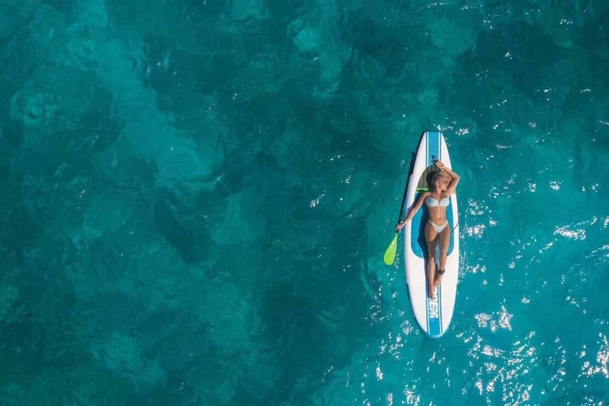 a person on a surfboard in the water aboard DOLCEVITACAT Yacht for Charter
