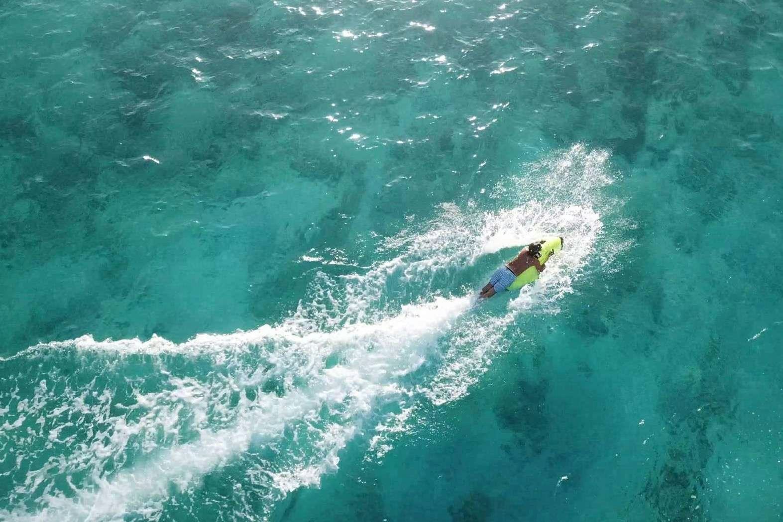 a person surfing on the waves aboard DOLCEVITACAT Yacht for Charter
