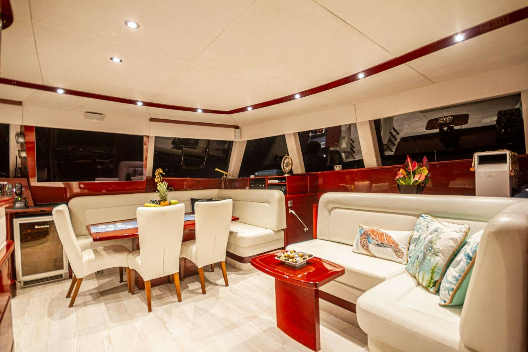 a room with a couch and a table and chairs aboard DOLCEVITACAT Yacht for Charter