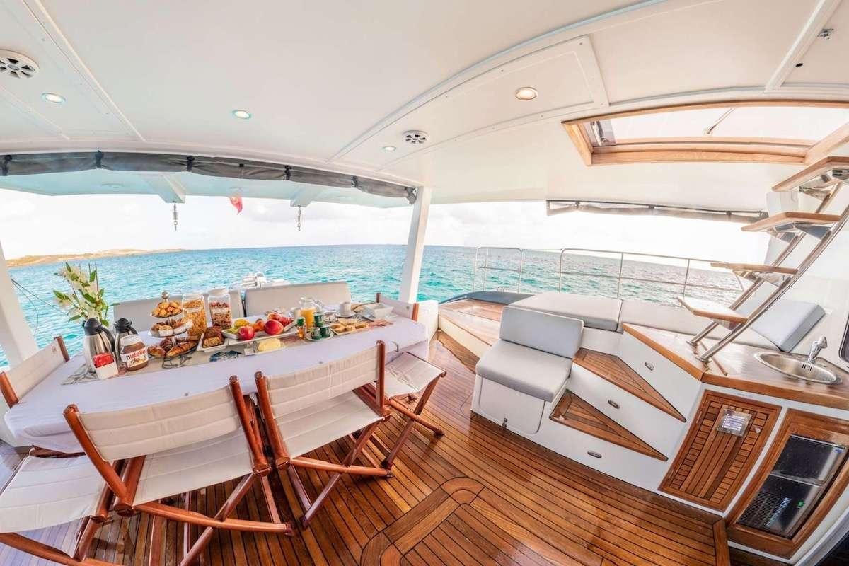 a room with a table and chairs aboard DOLCEVITACAT Yacht for Charter