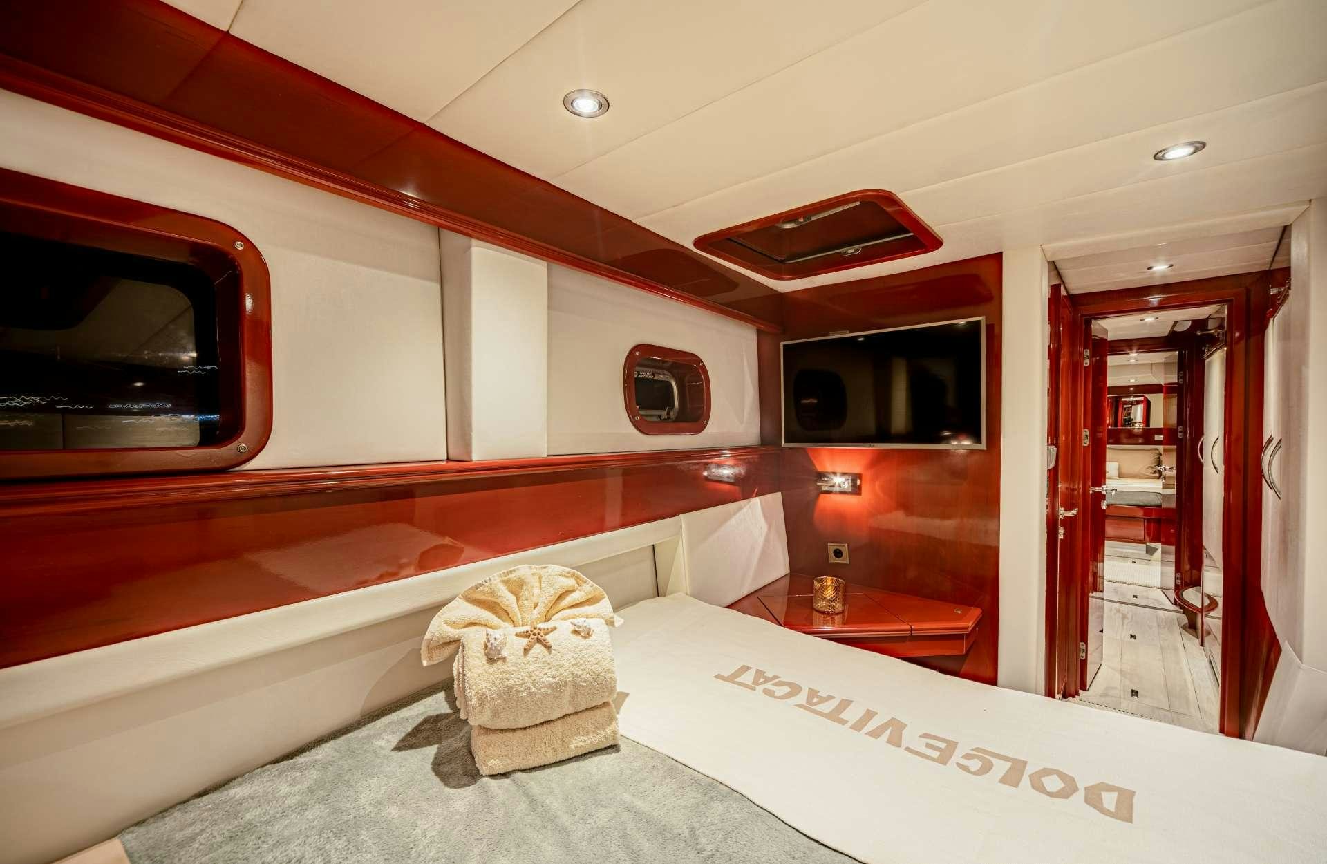 a room with a bed and a television aboard DOLCEVITACAT Yacht for Charter