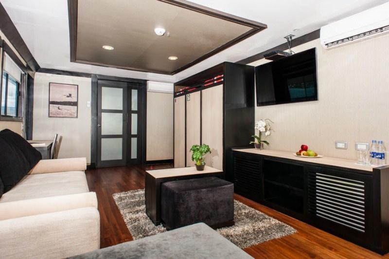 a living room with a large kitchen and a large tv aboard GALAPAGOS SEA STAR JOURNEY Yacht for Charter