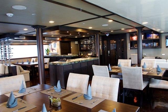 a restaurant with tables and chairs aboard GALAPAGOS SEA STAR JOURNEY Yacht for Charter