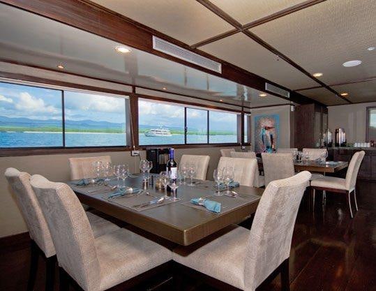 a large dining room with a large table and chairs aboard GALAPAGOS SEA STAR JOURNEY Yacht for Charter