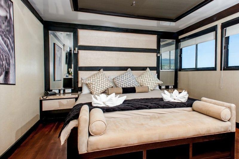 a bed with pillows on it aboard GALAPAGOS SEA STAR JOURNEY Yacht for Charter