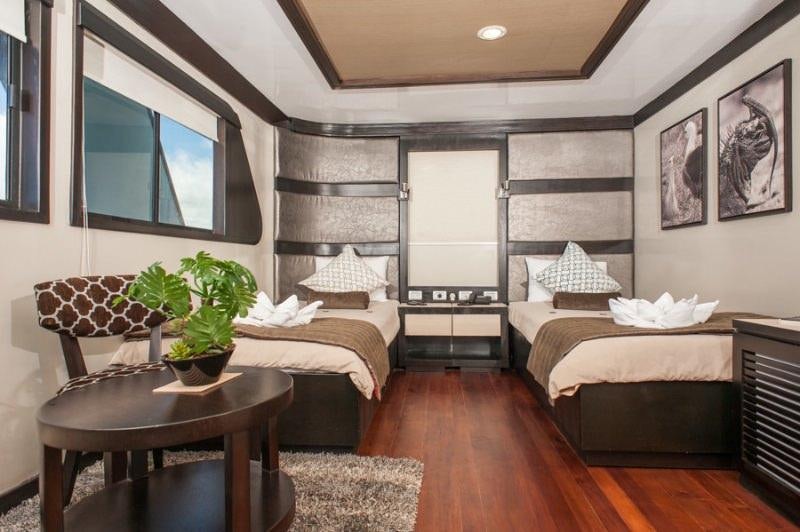 a room with a bed and a chair aboard GALAPAGOS SEA STAR JOURNEY Yacht for Charter