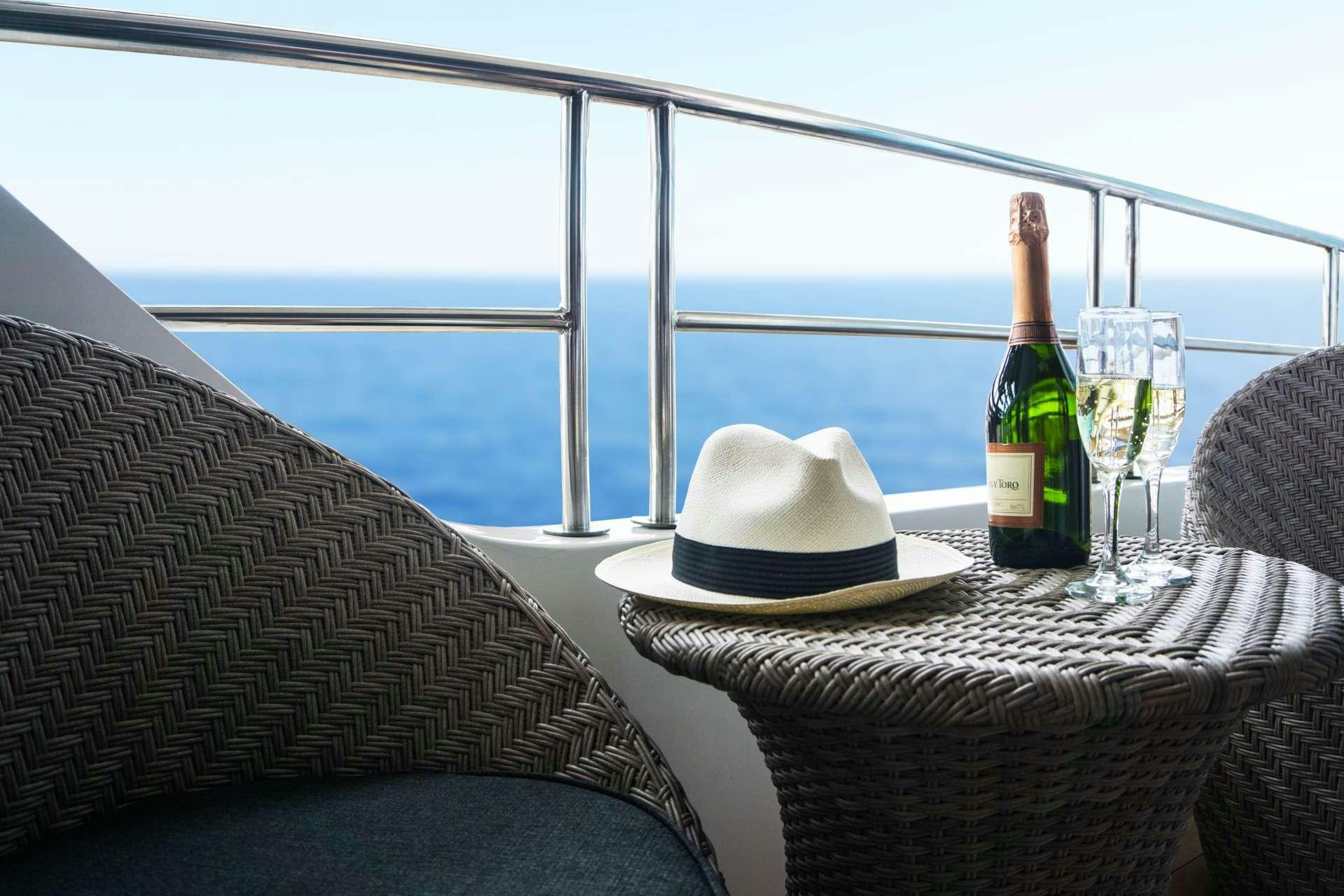 a bottle of wine and a glass on a table aboard INFINITY Yacht for Charter