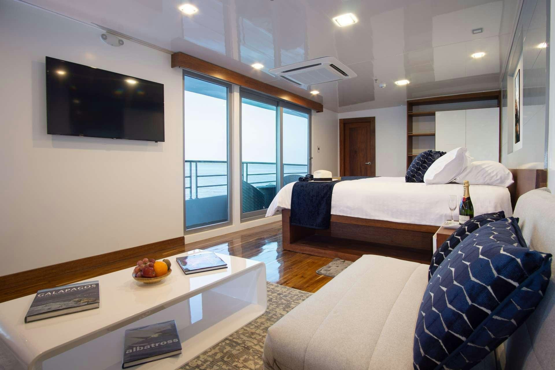 a room with a bed and a coffee table aboard INFINITY Yacht for Charter