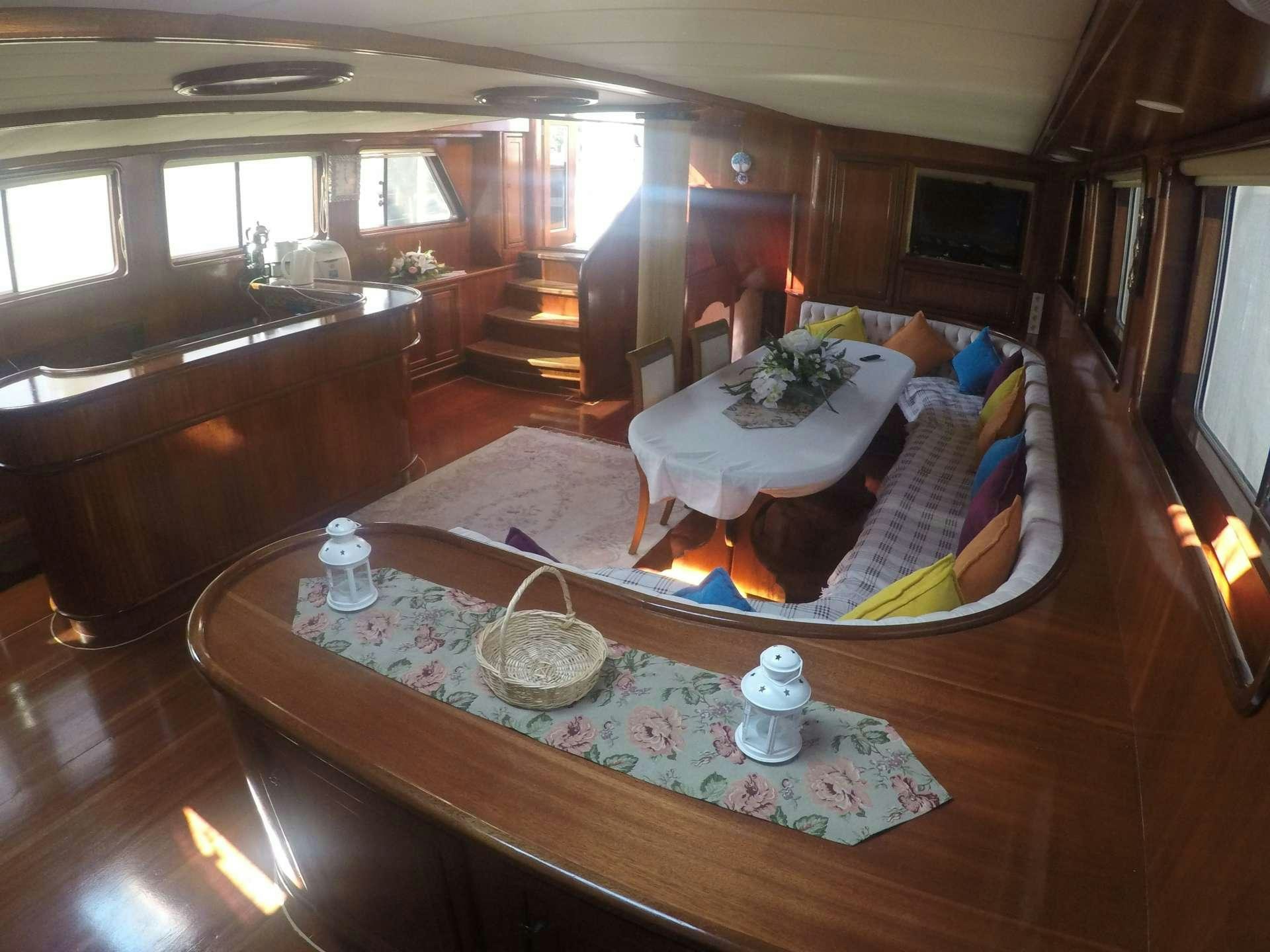 a living room with a large round table aboard PRENSES BUGCE Yacht for Charter