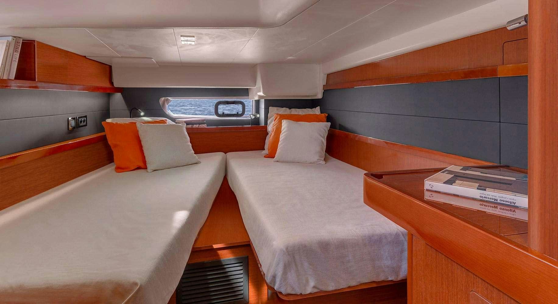 a room with beds and a desk aboard OCEAN STAR Yacht for Charter