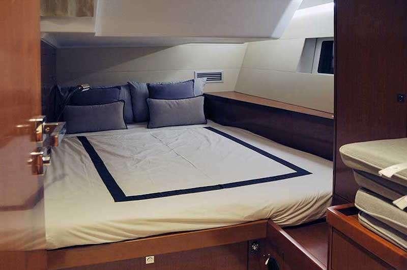 a bed with blue sheets aboard SIRIUS Yacht for Charter