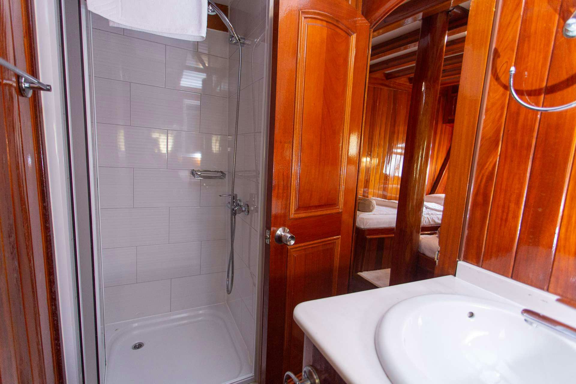 a bathroom with a bathtub and shower aboard KADENA Yacht for Charter