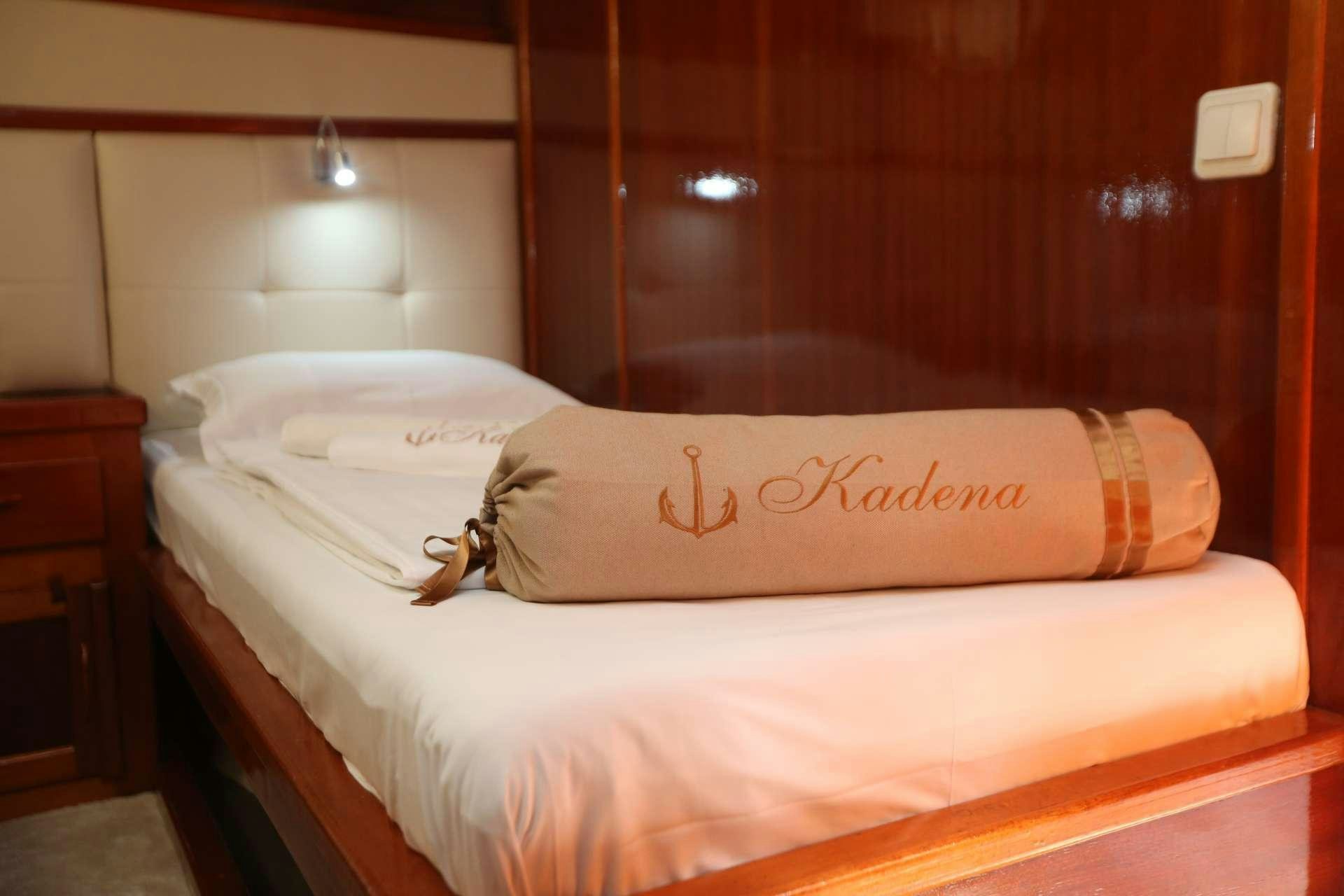 a bed with a pillow and a keychain on it aboard KADENA Yacht for Charter