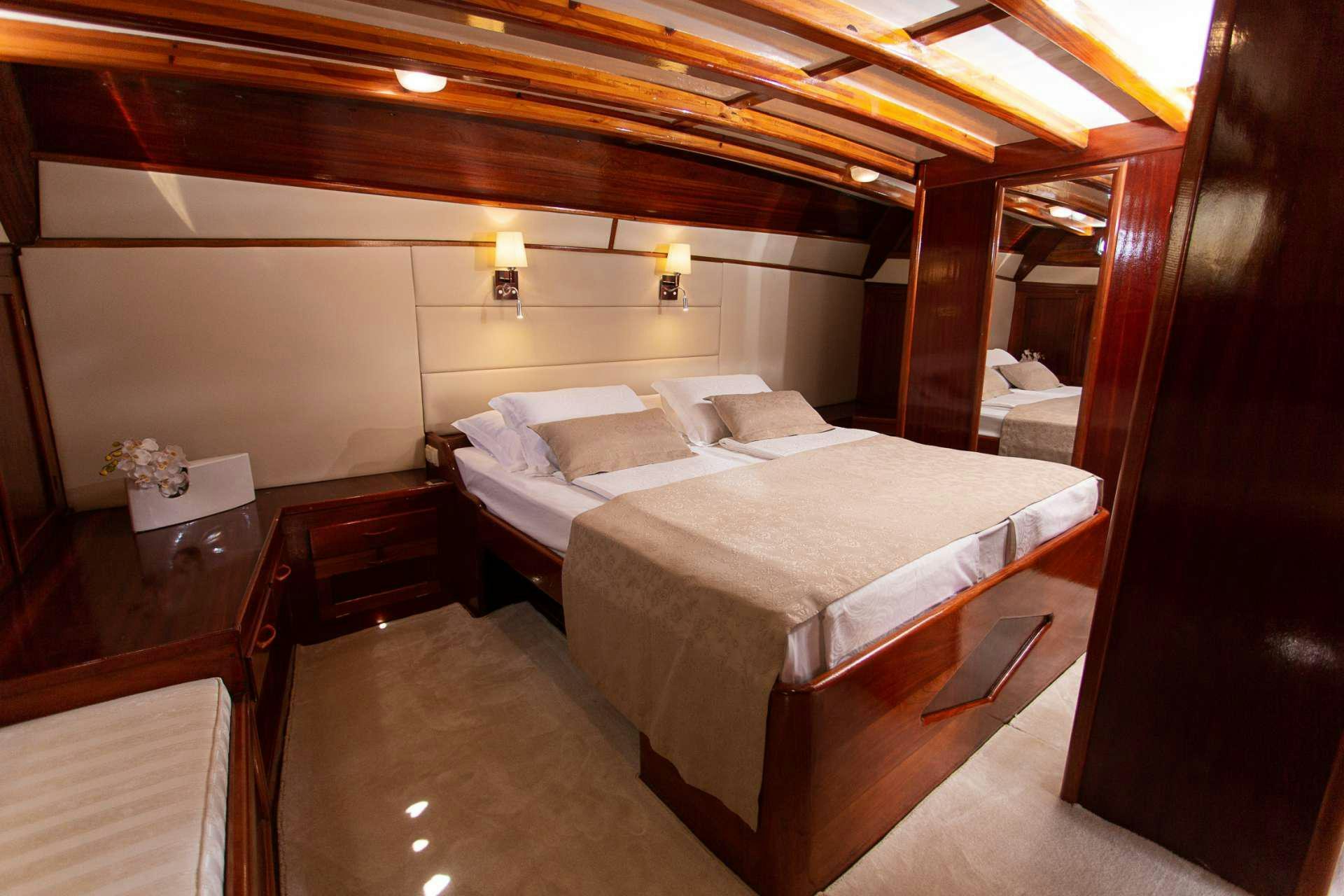 a room with a bed and a table aboard KADENA Yacht for Charter