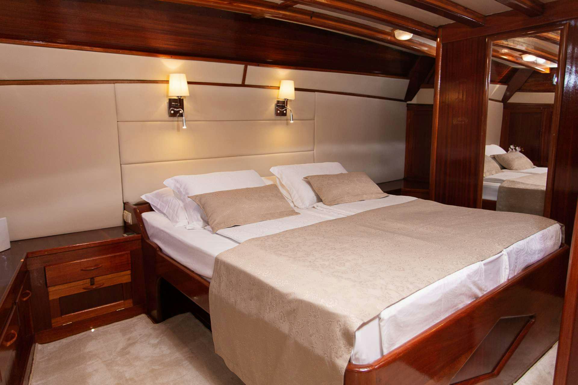 a bed with white sheets aboard KADENA Yacht for Charter