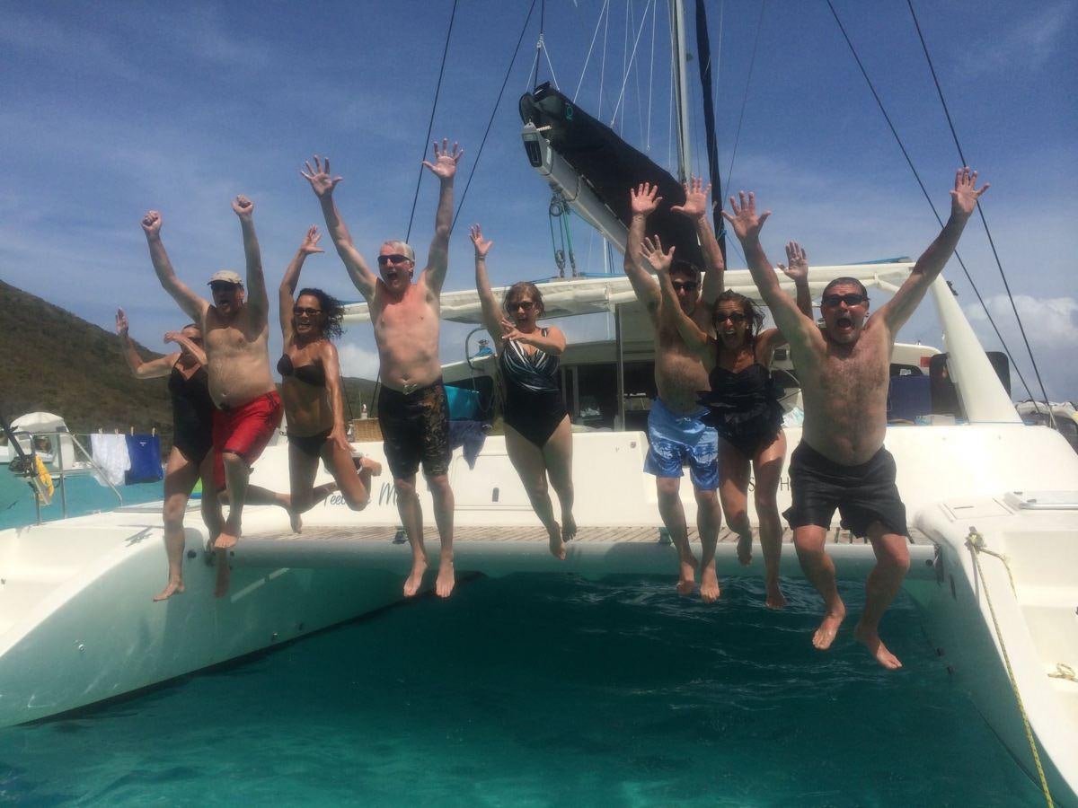 a group of people jumping into the water aboard FEEL THE MAGIC Yacht for Charter