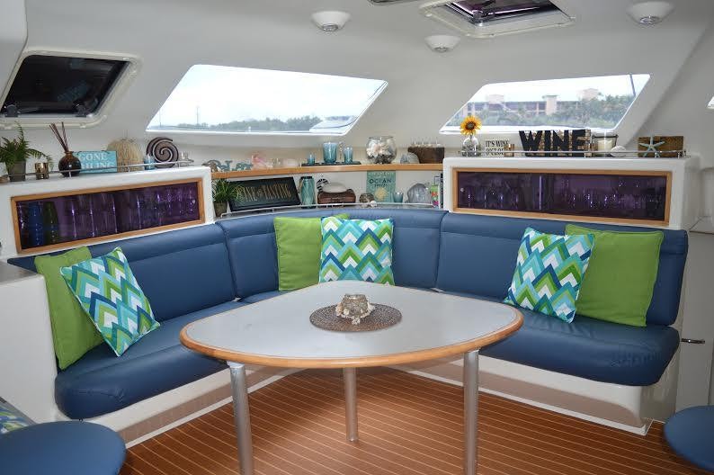 a living room with a blue couch and a table aboard FEEL THE MAGIC Yacht for Charter