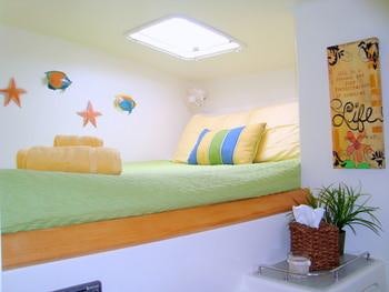 a room with a bed and a plant on the wall aboard FEEL THE MAGIC Yacht for Charter