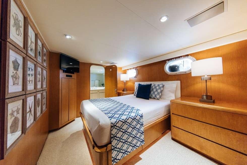 a bedroom with a bed and a lamp aboard UNLEASHED Yacht for Charter