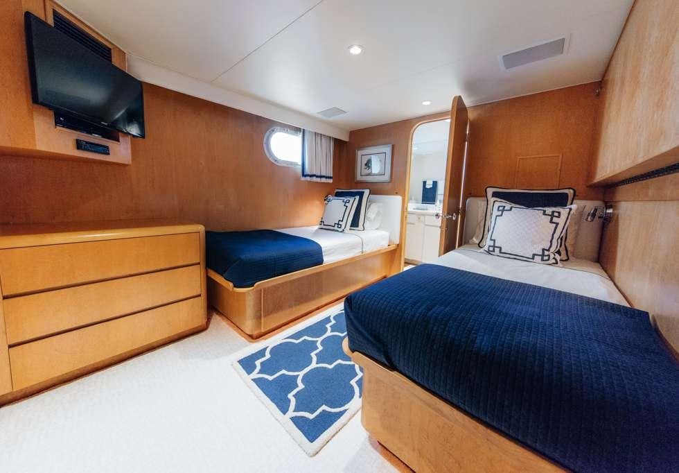 a room with a bed and a tv on the wall aboard UNLEASHED Yacht for Charter